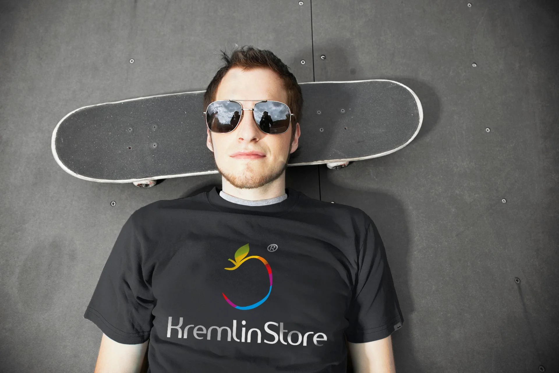 Парень в чёрной футболке KremlinStore со скейтбордом