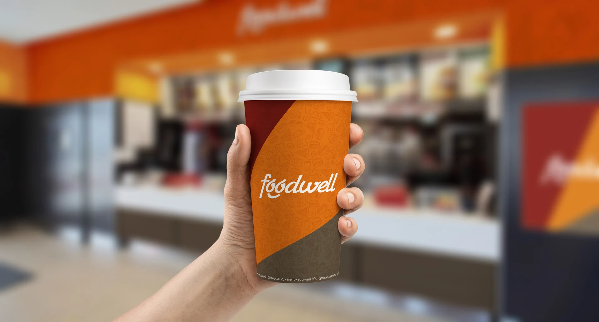 Рука со стаканом кофе Foodwell на фоне кафе