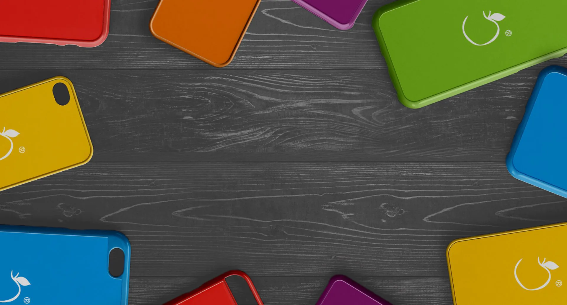 Разноцветные чехлы для iPhone на тёмном деревянном столе