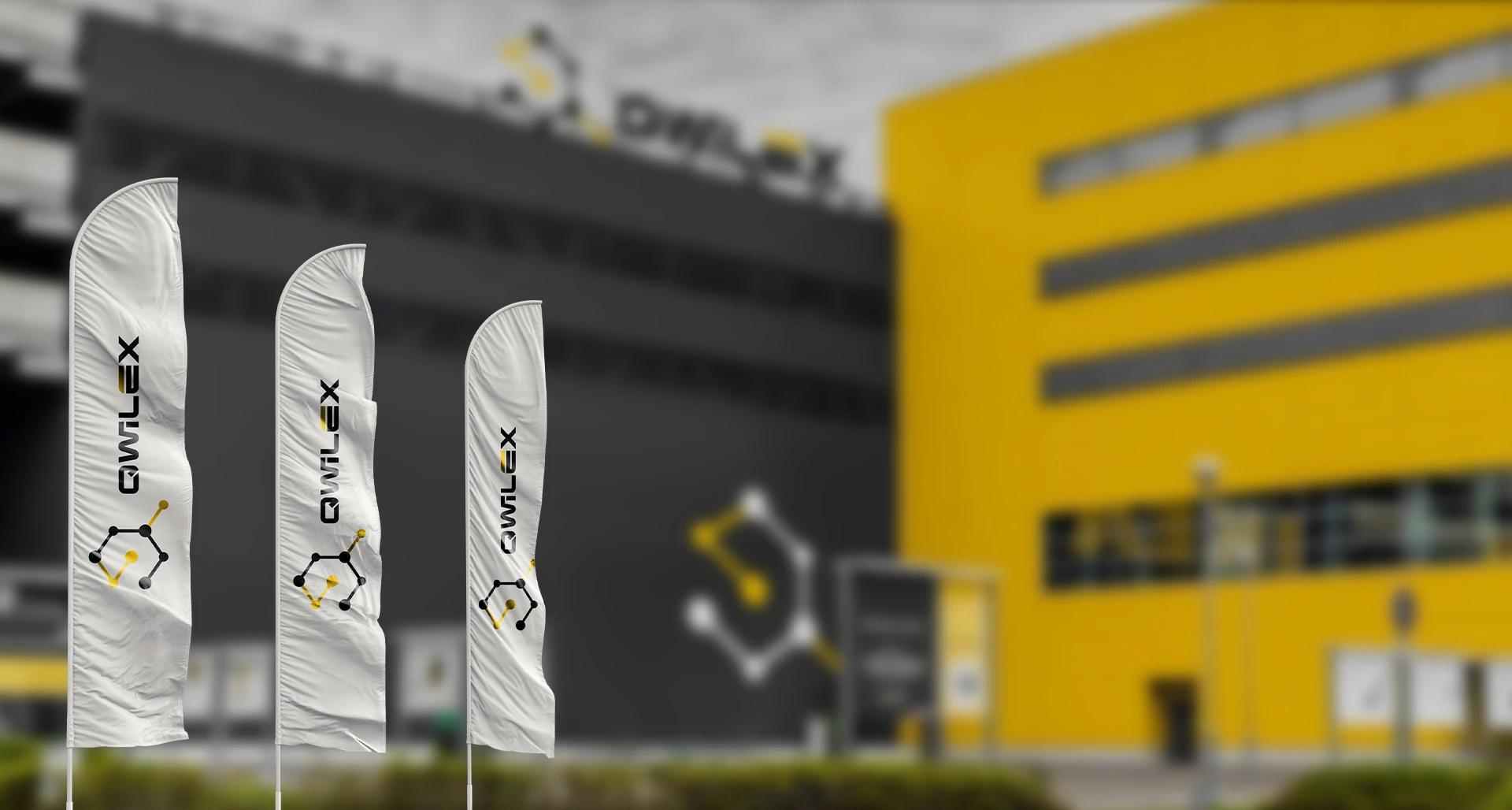 Флаги с логотипом Qwilex у жёлтого здания завода